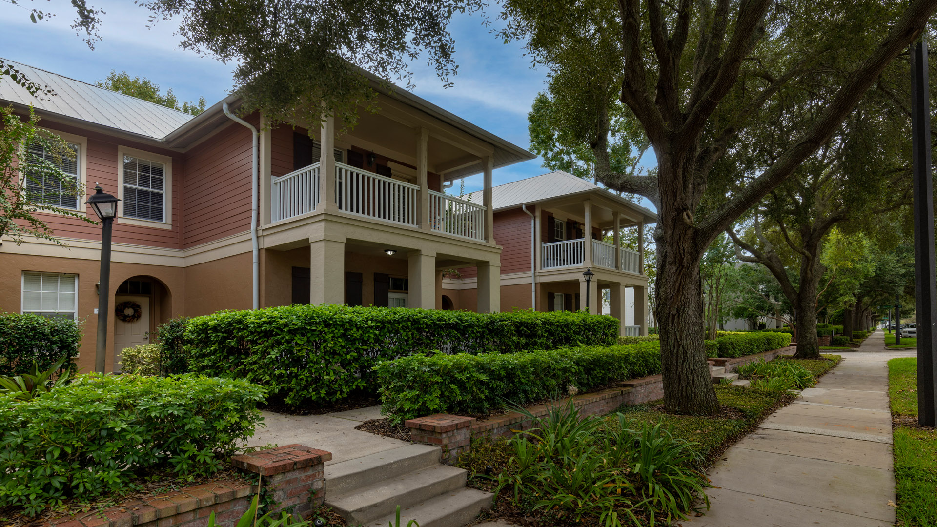 Exterior view of homes at Enders Place at Baldwin Park with balcony terrace and tree-lined sidewalks